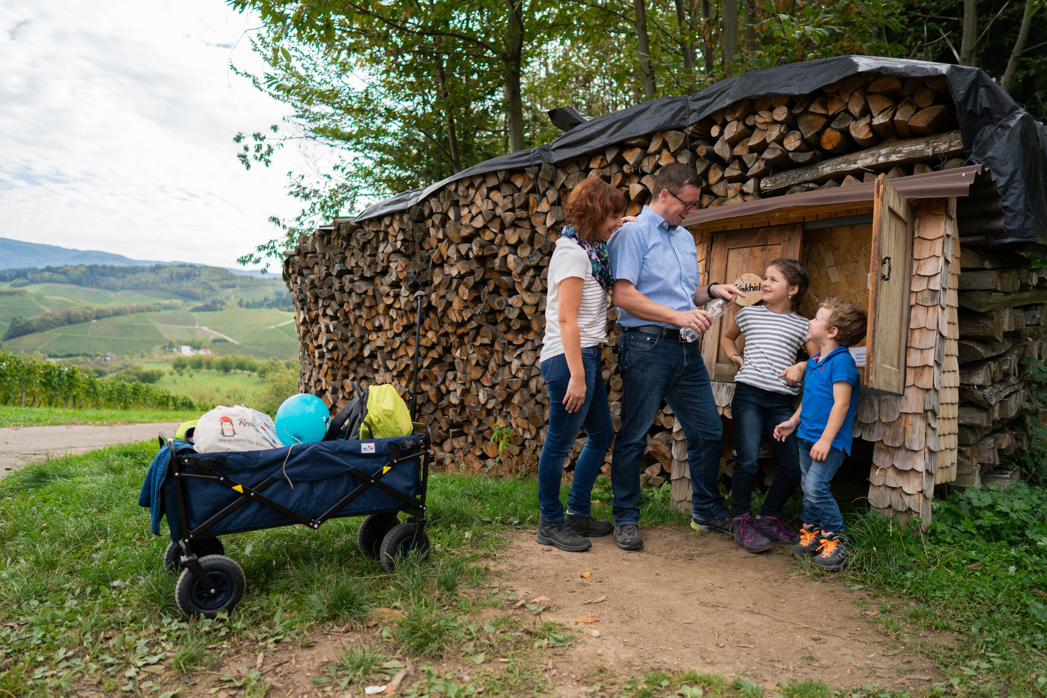 Familie steht vor Trinkhäuschen entlang der Rätseltour Annis Schwarzwald Geheimnis in Oberkirch
